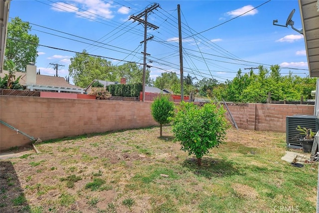 view of yard with a fenced backyard and central AC unit