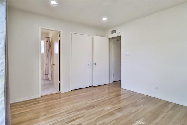 unfurnished bedroom with connected bathroom, light wood-style floors, recessed lighting, visible vents, and a closet