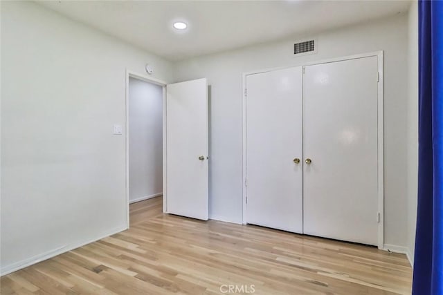 unfurnished bedroom with visible vents, baseboards, a closet, light wood finished floors, and recessed lighting