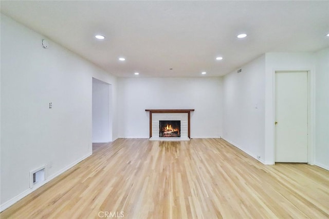unfurnished living room with recessed lighting, visible vents, light wood finished floors, and a fireplace