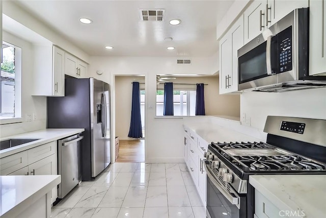 kitchen with visible vents, white cabinetry, and stainless steel appliances