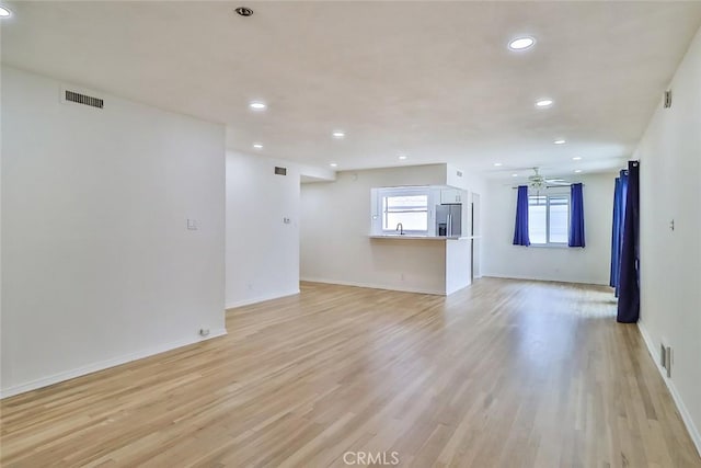 unfurnished living room featuring light wood-type flooring, recessed lighting, and visible vents