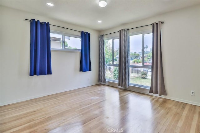 spare room featuring baseboards, recessed lighting, and wood finished floors
