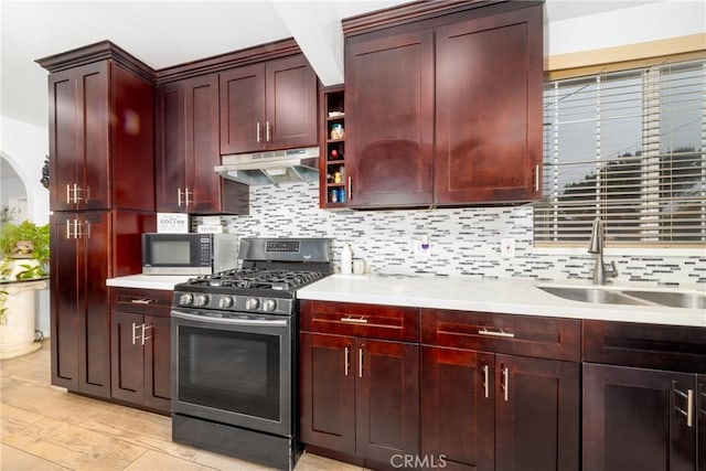12005 Washington Blvd, Whittier, CA 90606 - kitchen with stainless steel appliances, under cabinet range hood, dark brown cabinets, a sink, and tasteful backsplash