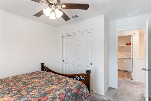bedroom with light colored carpet, ceiling fan, visible vents, and a closet