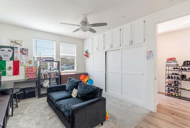 living area featuring light wood-type flooring and a ceiling fan