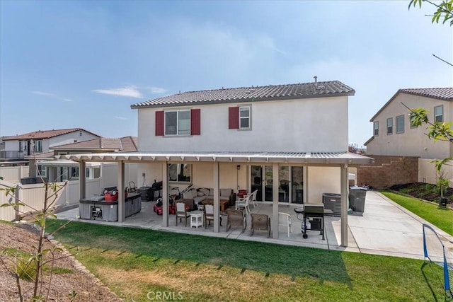 back of house with a fenced backyard, a patio area, stucco siding, and a yard