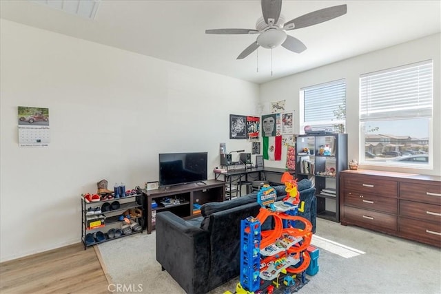 living room with ceiling fan, baseboards, and light wood-style flooring