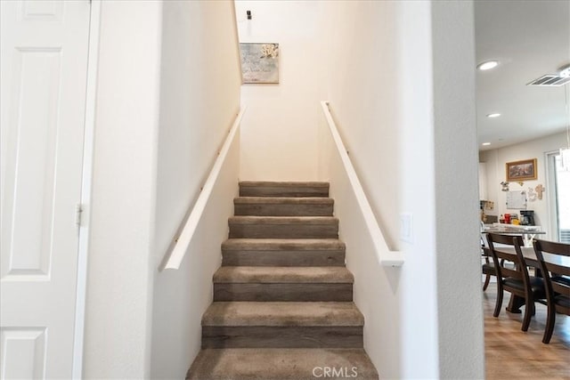 stairs featuring recessed lighting, wood finished floors, and visible vents