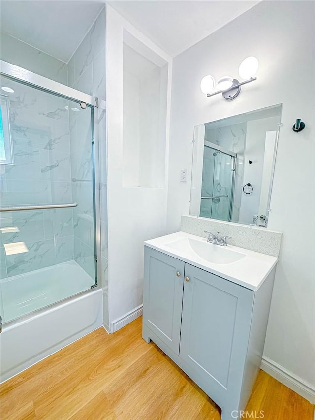4709 Bresee Ave, Baldwin Park, CA 91706 - full bath with vanity, baseboards, combined bath / shower with glass door, and wood finished floors