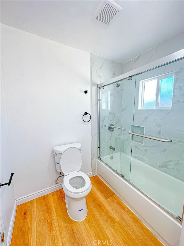 4709 Bresee Ave, Baldwin Park, CA 91706 - bathroom with toilet, baseboards, wood finished floors, visible vents, and bath / shower combo with glass door