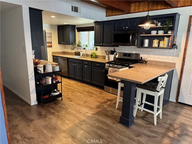 31347 Oakleaf Dr, Running Springs, CA 92382 - kitchen featuring a peninsula, appliances with stainless steel finishes, a sink, and tasteful backsplash