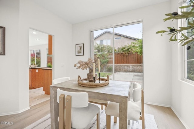 dining room with a wealth of natural light and light wood-style flooring