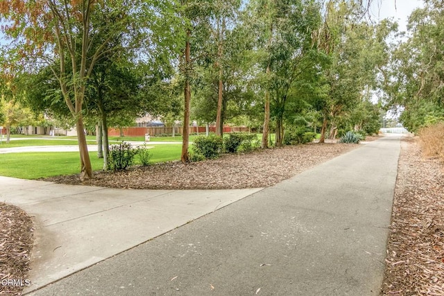 view of home's community with fence and a lawn