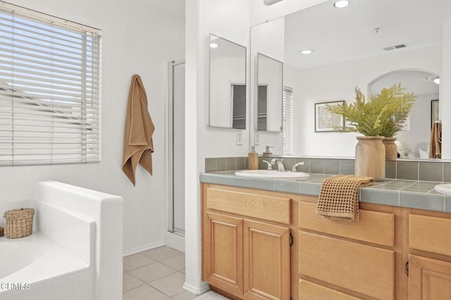 bathroom featuring double vanity, a garden tub, a sink, tile patterned floors, and visible vents