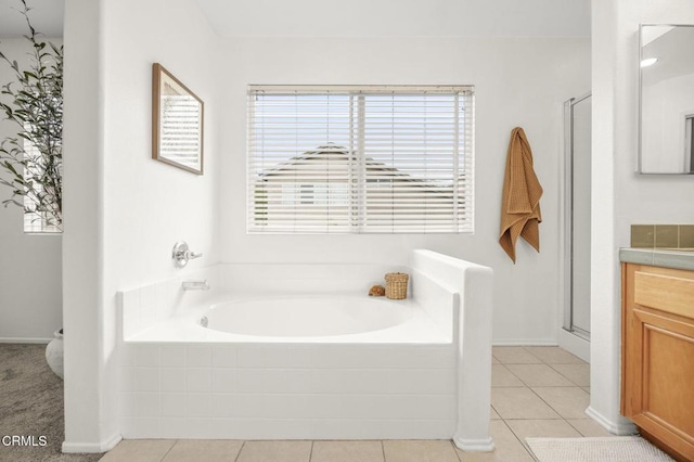 full bath featuring a stall shower, baseboards, a bath, tile patterned flooring, and vanity