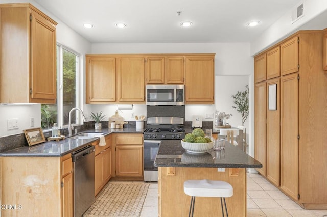 kitchen featuring dark stone counters, appliances with stainless steel finishes, visible vents, and a sink