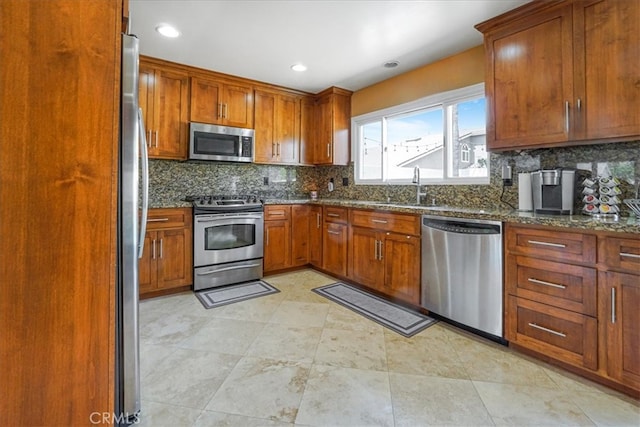 4433 E Justice Cir, Orange, CA 92869 - kitchen with a sink, dark stone counters, brown cabinetry, appliances with stainless steel finishes, and decorative backsplash