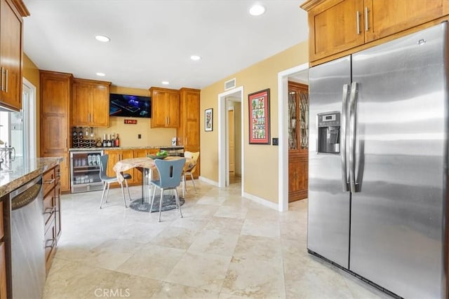 4433 E Justice Cir, Orange, CA 92869 - kitchen with stainless steel appliances, brown cabinets, light stone counters, visible vents, and beverage cooler