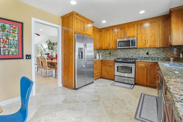 4433 E Justice Cir, Orange, CA 92869 - kitchen featuring appliances with stainless steel finishes, brown cabinetry, tasteful backsplash, and a sink