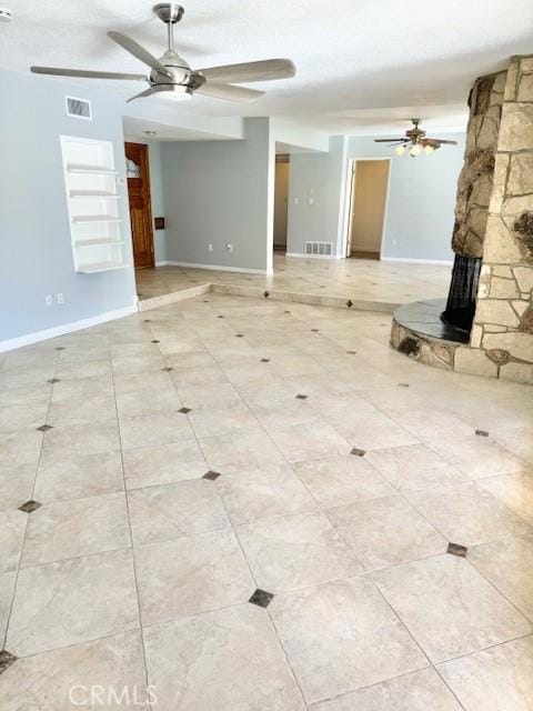 unfurnished living room with a ceiling fan, baseboards, and visible vents