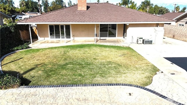 back of house with a patio area, fence, stucco siding, and a chimney