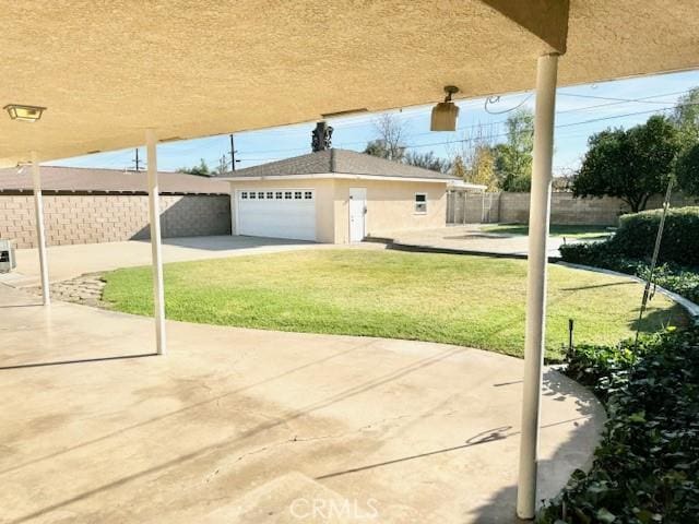 view of patio / terrace with concrete driveway, a garage, and fence