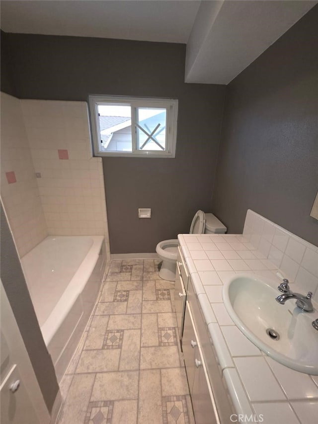full bathroom with toilet, a bathtub, baseboards, walk in shower, and vanity