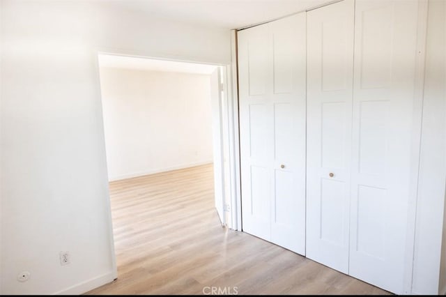 interior space featuring baseboards, wood finished floors, and a closet