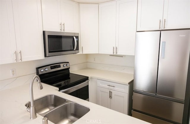 kitchen with white cabinets, appliances with stainless steel finishes, and a sink
