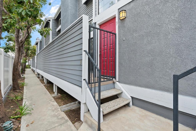 view of exterior entry featuring fence