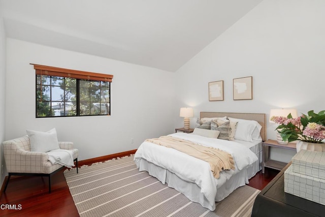 bedroom with baseboards, vaulted ceiling, and wood finished floors