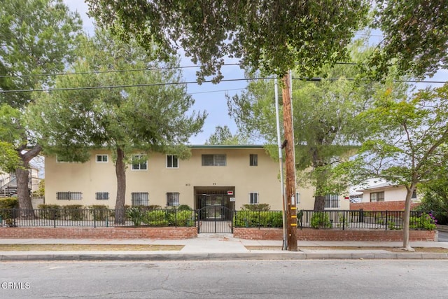 view of front of home with a fenced front yard and stucco siding