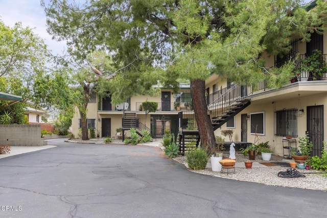 exterior space with stairway and stucco siding