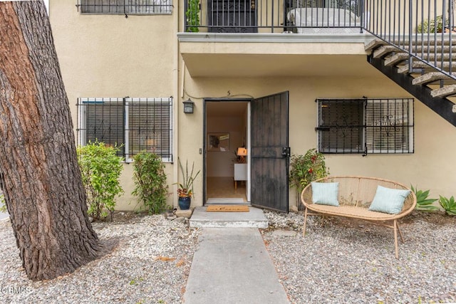 doorway to property featuring a balcony and stucco siding