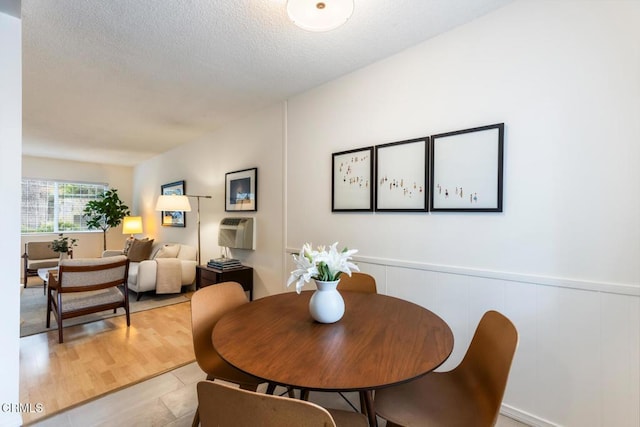dining room featuring wainscoting and a textured ceiling