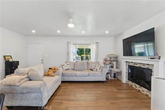 living area with light wood-style floors, recessed lighting, and a fireplace