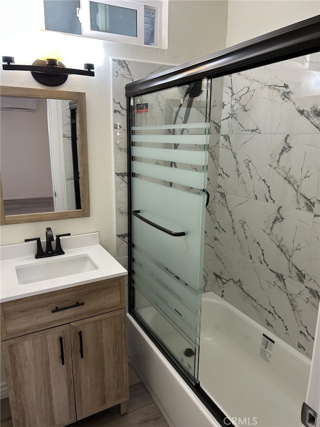 bathroom with shower / bath combination with glass door, vanity, and wood finished floors