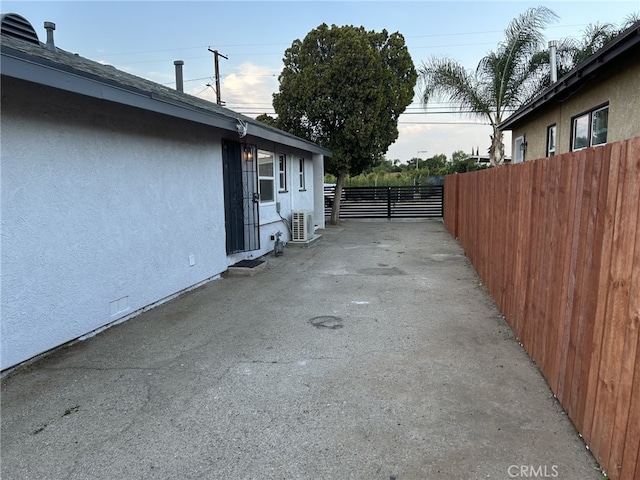 view of side of property with stucco siding and fence