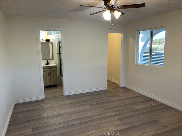 4832 Mitchell Ave, Riverside, CA 92505 - unfurnished bedroom with wood finished floors, a textured ceiling, connected bathroom, and a ceiling fan