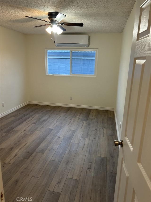 4832 Mitchell Ave, Riverside, CA 92505 - unfurnished room featuring a wall unit AC, dark wood-style floors, a ceiling fan, and a textured ceiling