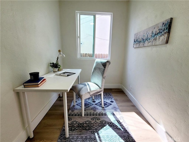 office with baseboards, a textured wall, and wood finished floors