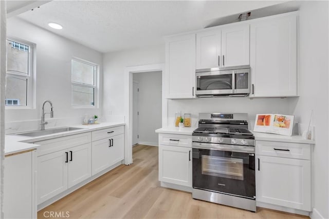1629 E 114th St, Los Angeles, CA 90059 - kitchen featuring appliances with stainless steel finishes, a sink, light countertops, a textured ceiling, and recessed lighting