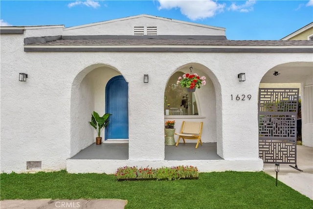 1629 E 114th St, Los Angeles, CA 90059 - doorway to property featuring covered porch, stucco siding, and roof with shingles