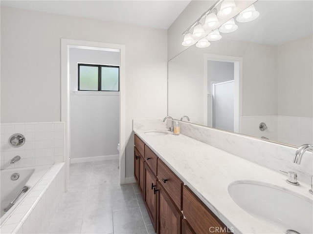 bathroom with a sink, baseboards, tile patterned flooring, and double vanity