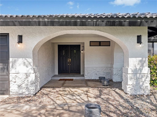 entrance to property featuring stucco siding