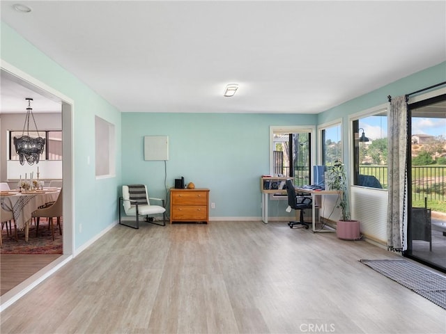 office area featuring baseboards, a chandelier, and wood finished floors