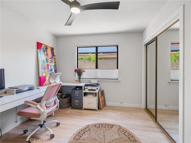 office space featuring baseboards, a ceiling fan, and wood finished floors
