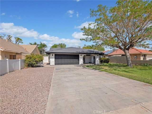 ranch-style home with fence, a front yard, stucco siding, driveway, and a tile roof