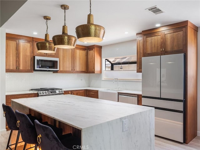 kitchen featuring a sink, appliances with stainless steel finishes, tasteful backsplash, and visible vents
